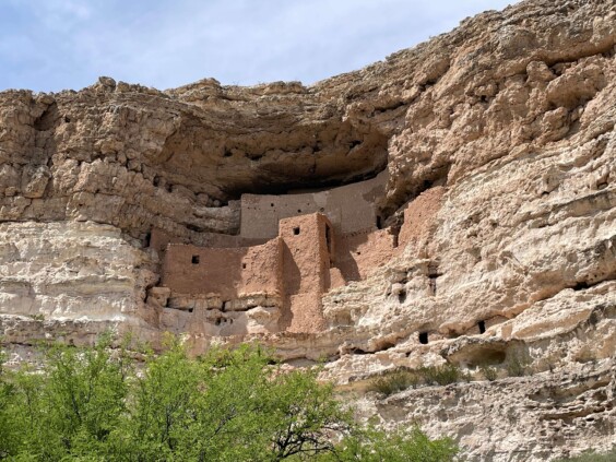 Multi-story cliff dwelling built into natural limestone alcove high on cliff face