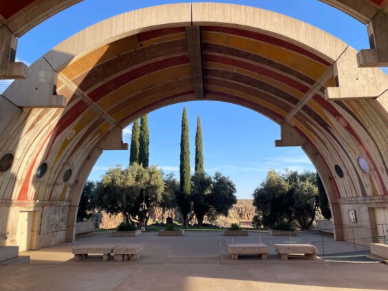 Large curved concrete vault structure with geometric openings casting dramatic shadows