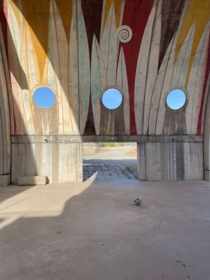 Interior view of semicircular concrete shell structure with circular window openings