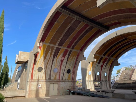 Concrete buildings with curved forms and arched openings on desert hillside