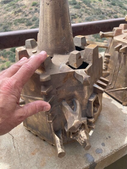 Large ornate bronze bell with sculptural decorative elements hanging on display