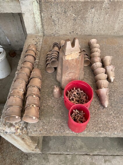 Collection of small bronze bell parts and finished bells arranged on table